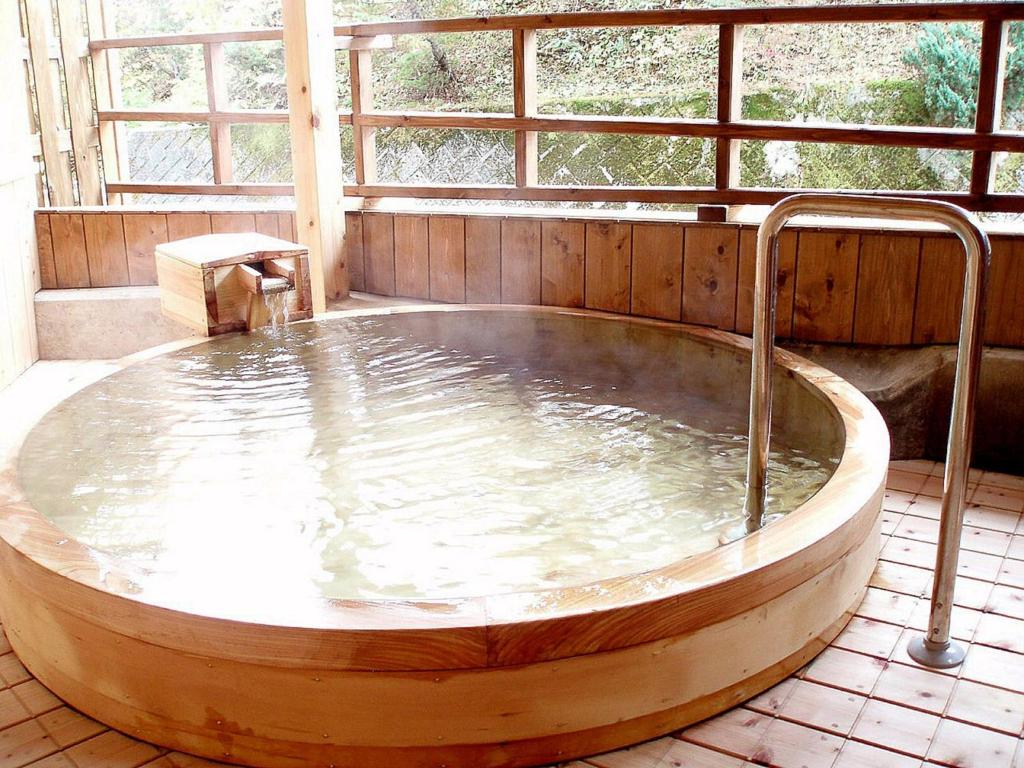 a large wooden bath tub in a room at Mori no RyoTei Mount Bandai - Vacation STAY 43099 in Numajiri