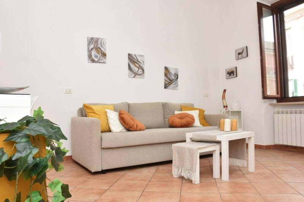 Home in Certosa Pigneto con parcheggio في روما: غرفة معيشة مع أريكة وطاولة