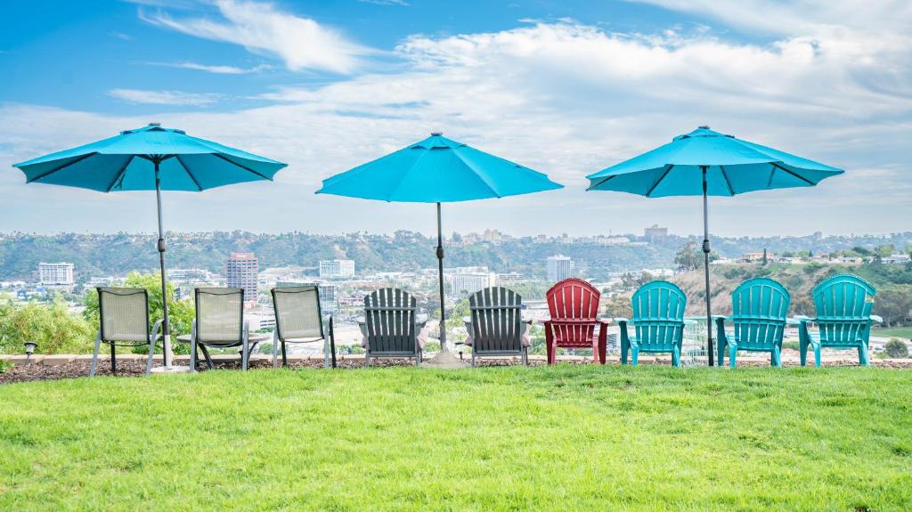 een groep stoelen en paraplu's op een veld bij Home Ensuite With Panoramic City View in San Diego