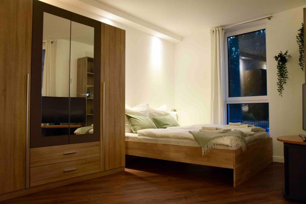 a bedroom with a bed and a large glass cabinet at Stilvolle Wohnung mit Balkon & Parkplatz in Rostock