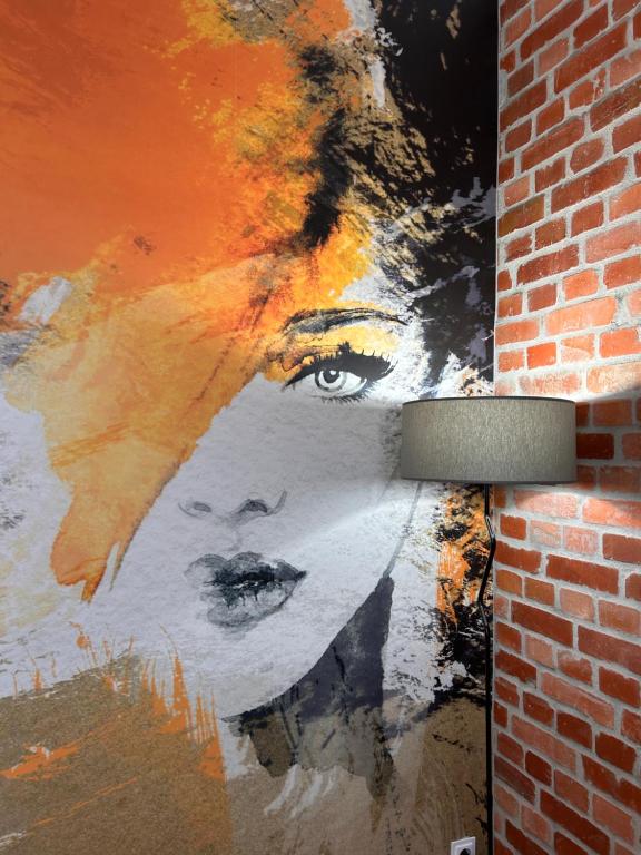 a painting of a woman on the side of a brick wall at BoleslaviaApartments - Apartament Simon 2, Center, air conditioning in Bolesławiec