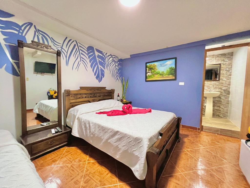 1 dormitorio con 1 cama grande y espejo en Hostal Mom Mariela, en San Andrés