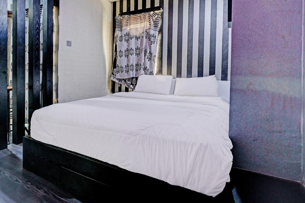 un grande letto bianco in una stanza con finestra di OYO Life 93120 Apartement Gateway Cicadas By Sarana Cipta Mahakarya a Bandung