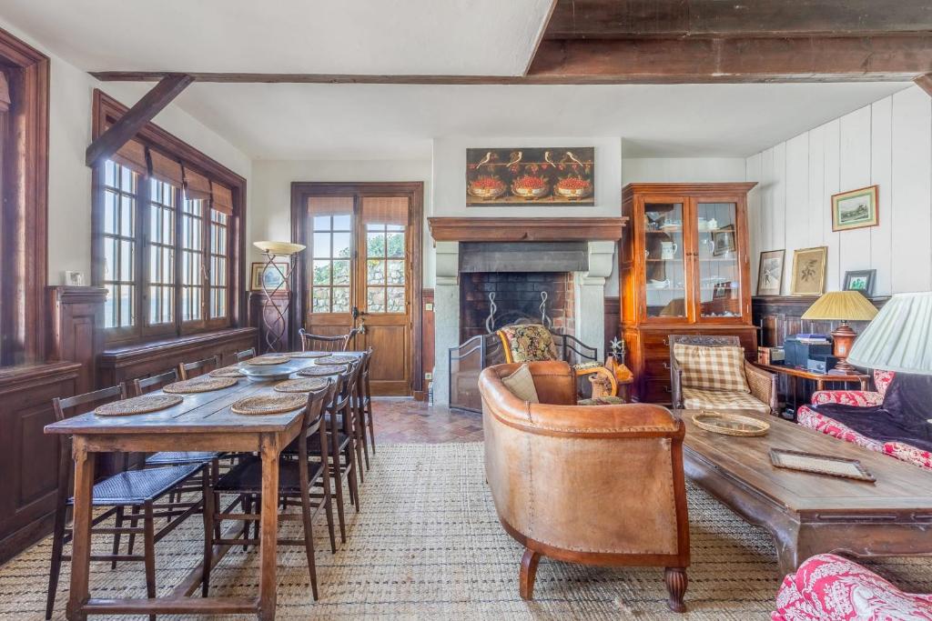 - un salon avec une grande table et une cheminée dans l'établissement Maison Mahu - Welkeys, à Villerville