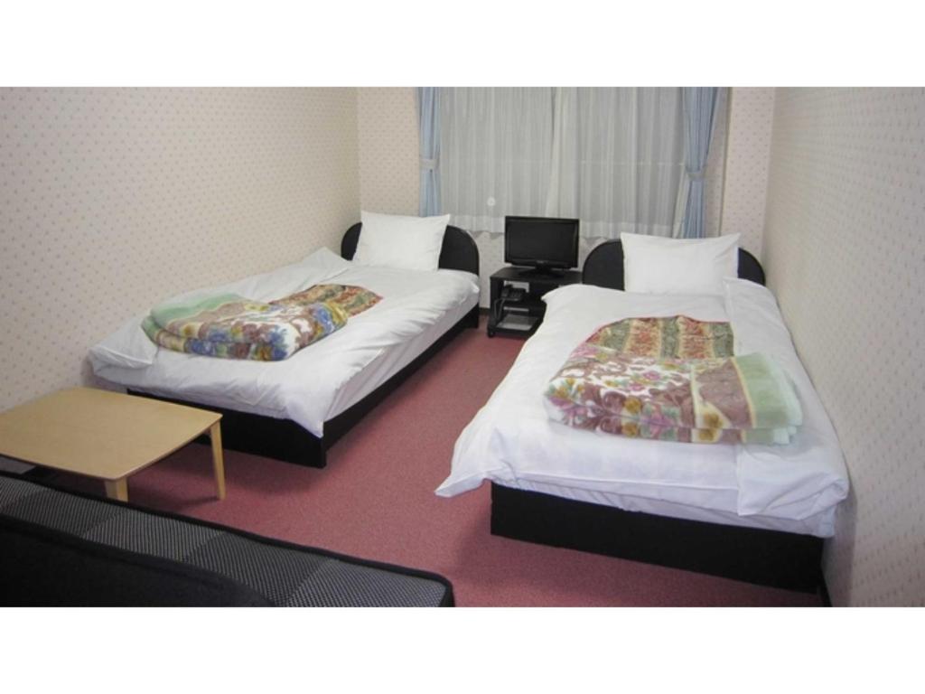 a room with two beds and a table and a desk at Pension Kitashirakawa - Vacation STAY 91700v in Kyoto