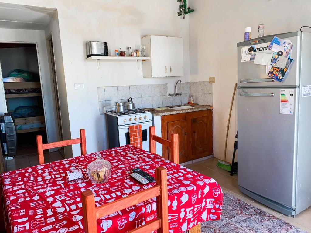 a kitchen with a table and a refrigerator at Alojamiento Gonzalez Paz in Puerto Madryn