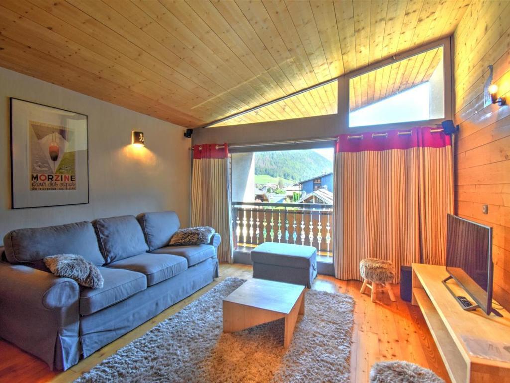 un salon avec un canapé et une table dans l'établissement Morzine : Apt 6 pers, 2 ch, cuisine équipée, balcon, parking, casier à skis - FR-1-524-119, à Morzine