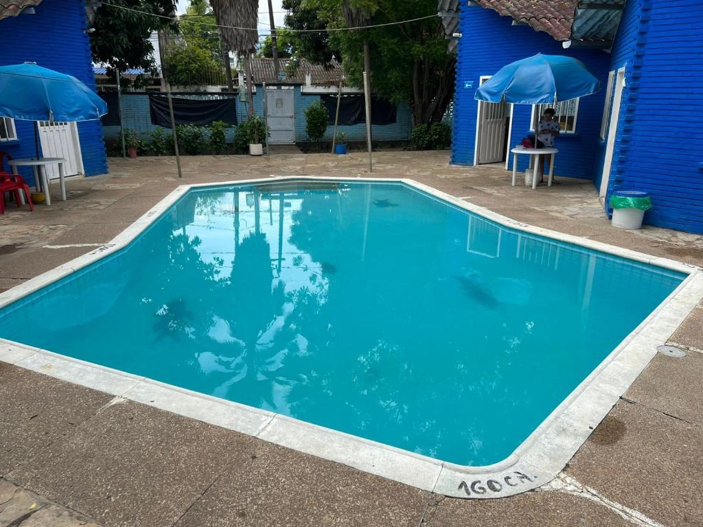 een blauw zwembad voor een blauw gebouw bij Cabañas Las Gemelas in Melgar