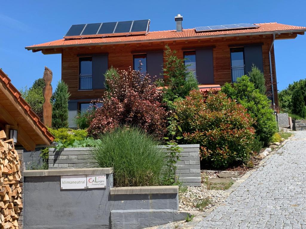 une maison avec des panneaux solaires sur le toit dans l'établissement CaLegna Ferienchalet, à Bad Kohlgrub