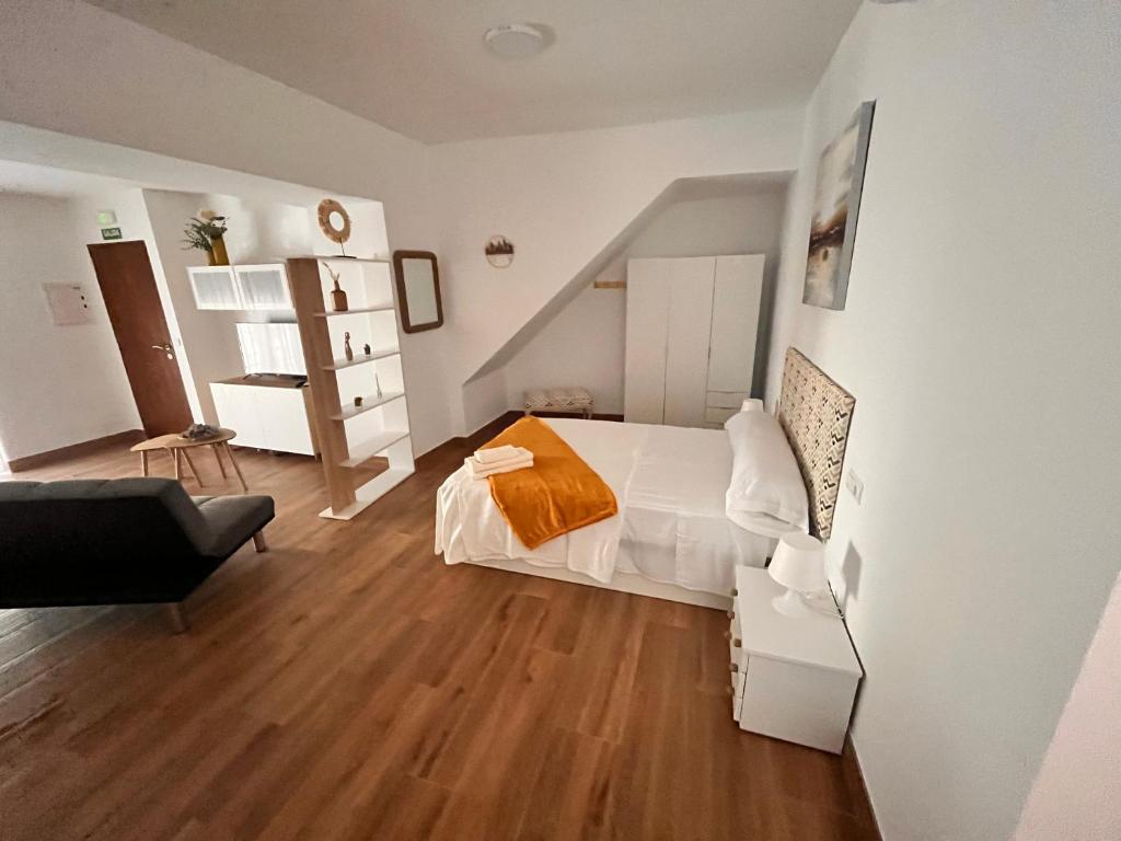 um quarto com uma cama e uma cadeira em Apartamentos EL PELIGRO 5 ZAGUAN em Archidona