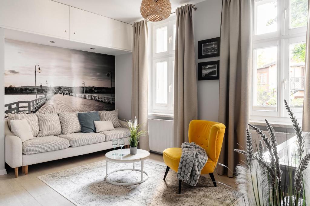 - un salon avec un canapé et une table dans l'établissement Sanhaus Apartments - Apartament LIDO - 300 m od plaży, à Sopot