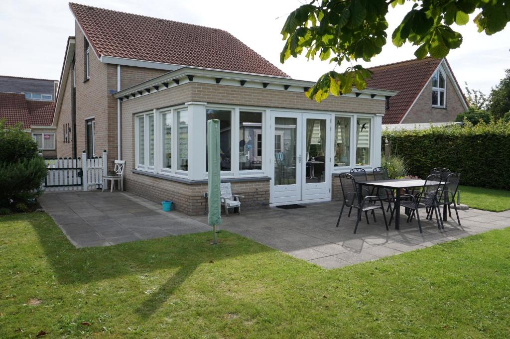 a screened in patio with a table and chairs at Kustverhuur, Park Scheldeveste , Schelde 095 in Breskens