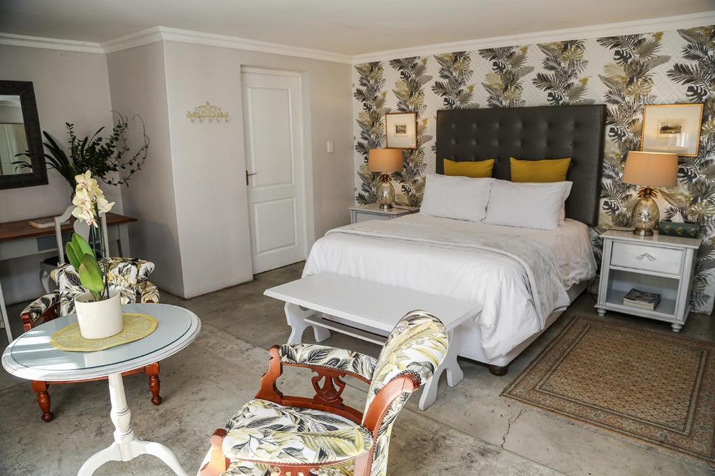 a bedroom with a bed and a table and a couch at 5 Konings Guesthouse in Paarl