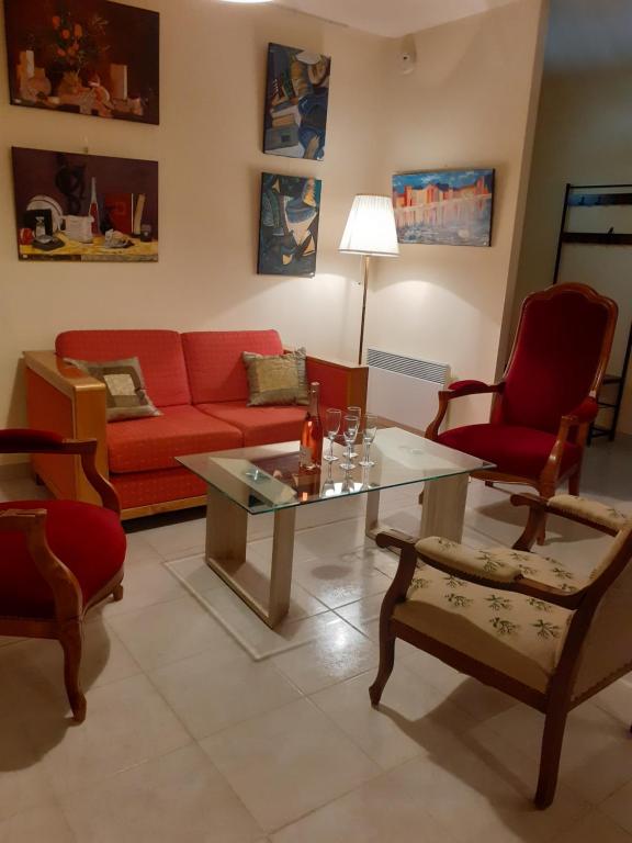 - un salon avec un canapé et des fauteuils rouges dans l'établissement La villa Le Petit Bois, près Rocamadour, Padirac, à Lavergne