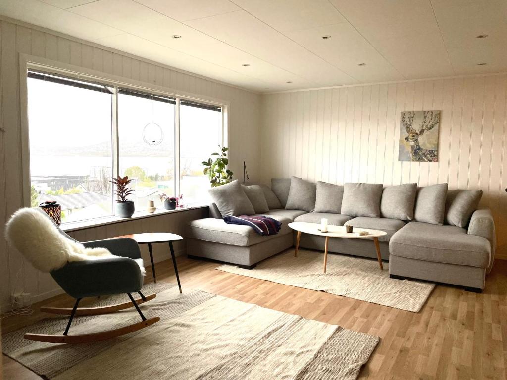 een woonkamer met een bank en een stoel bij Penthouse with panorama view and great location! in Tromsø