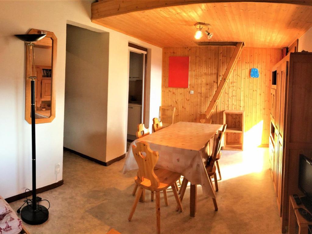 ein Esszimmer mit einem Holztisch und Stühlen in der Unterkunft 2 Pièces 6 Pers Sud à 150m des Pistes - FR-1-416-4 in La Toussuire