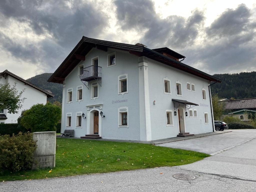 a white building with a balcony on a street at Appartement Stahlhammer in Flachau