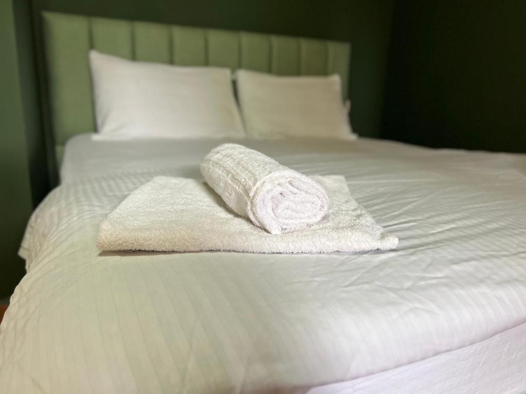 ein weißes Handtuch auf dem Bett in der Unterkunft Tirana Rooms in Tirana