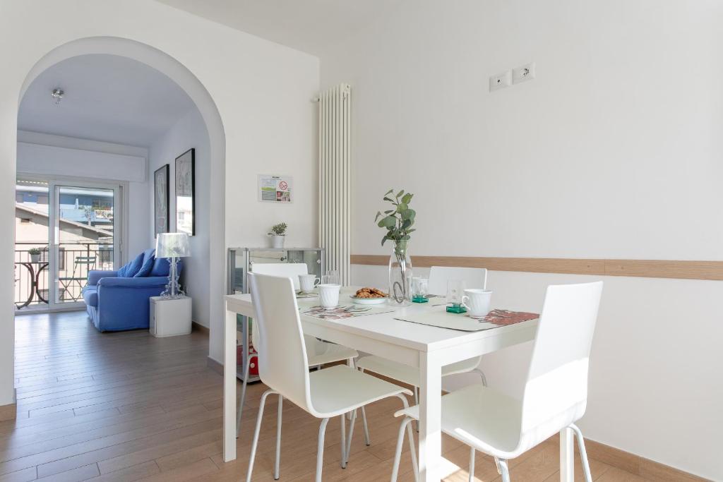 - une salle à manger blanche avec une table et des chaises blanches dans l'établissement Grazioso appartamento seconda fila sul mare - wifi, à Roseto degli Abruzzi