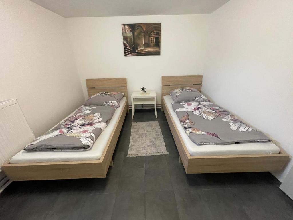 2 camas en una habitación pequeña con mesa en Handwerkerwohnung KG Sutterain, 