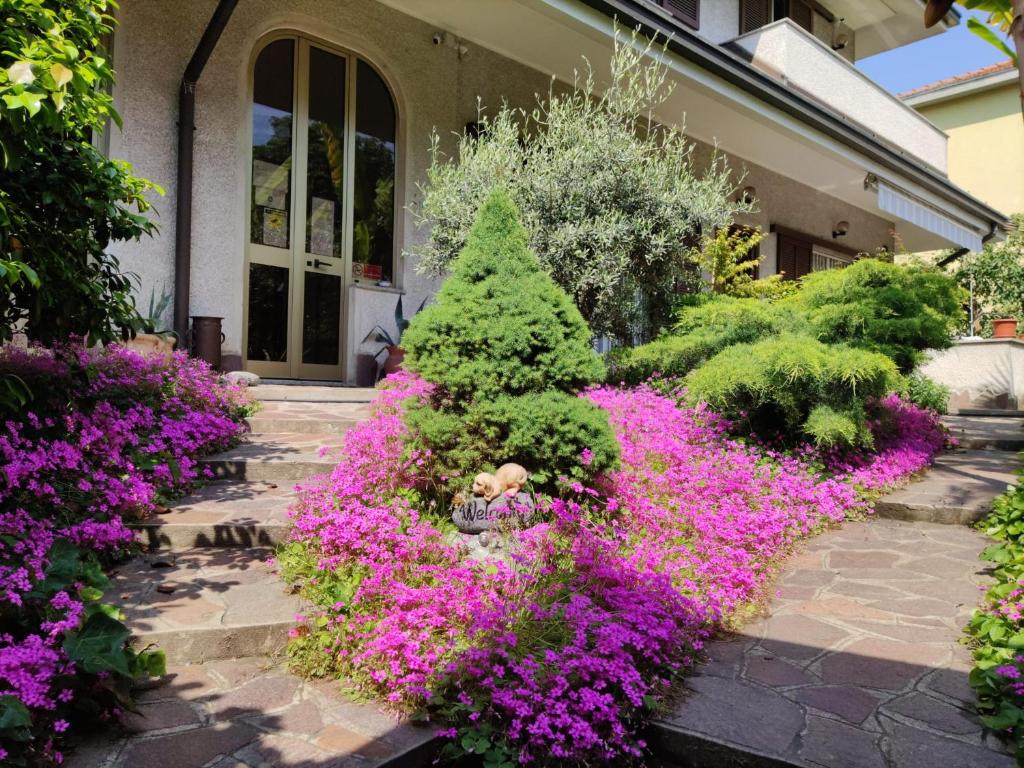 a garden with pink flowers in front of a house at B&B Ariosto 26 in Rho