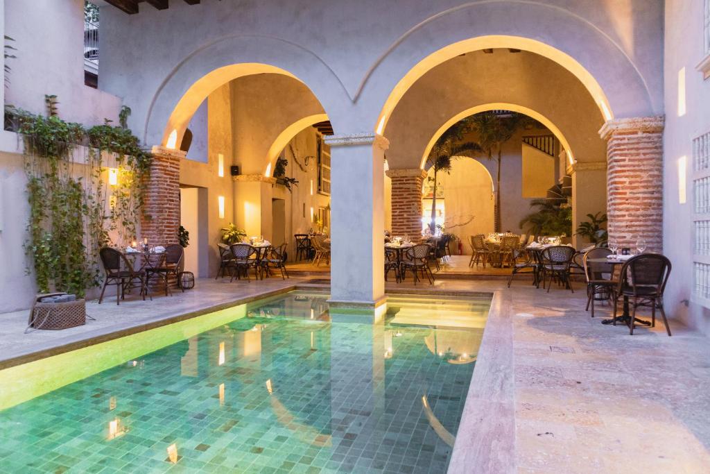 an indoor pool in a building with chairs and tables at Hotel Casa Don Luis by Faranda Boutique, a member of Radisson Individuals in Cartagena de Indias