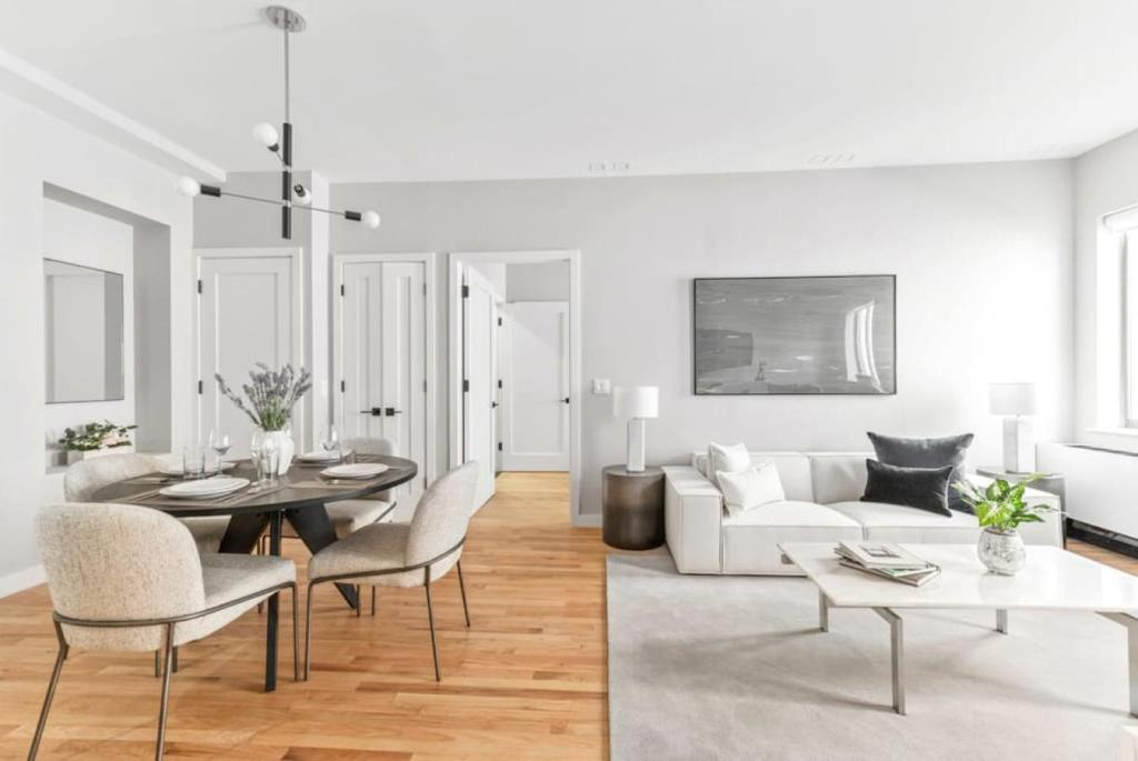 un soggiorno bianco con divano bianco e tavolo di Top Notch 2BR in Upper East Mins to Central Park a New York