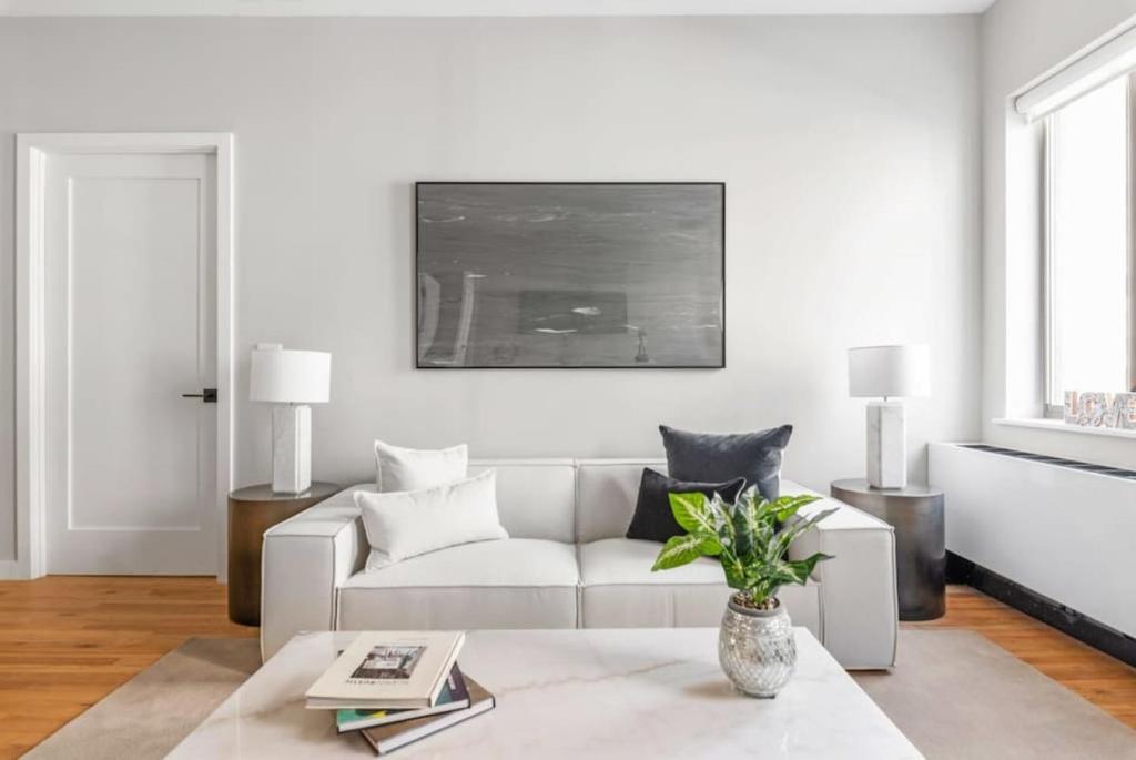 a white living room with a white couch at Top Notch 2BR Suite Minutes to Central Park in New York
