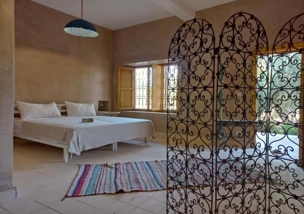 a bedroom with a bed and a wrought iron gate at RIAD AMAN SKOURA in Skoura