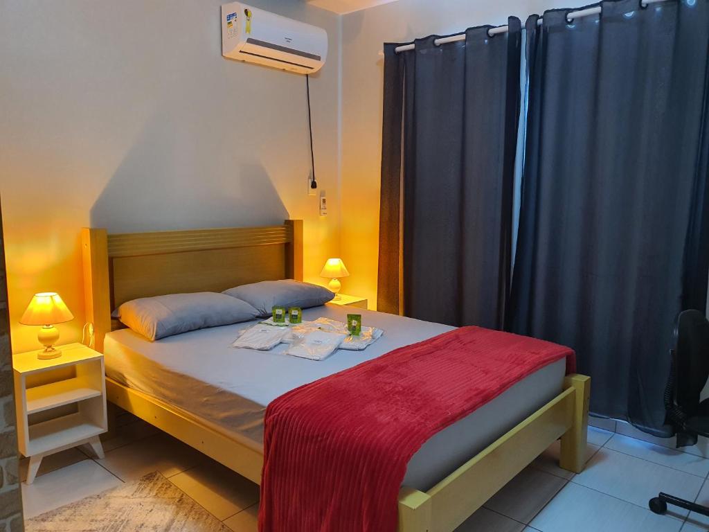 1 dormitorio con 1 cama con manta roja en Apartamento Inteiro en Blumenau