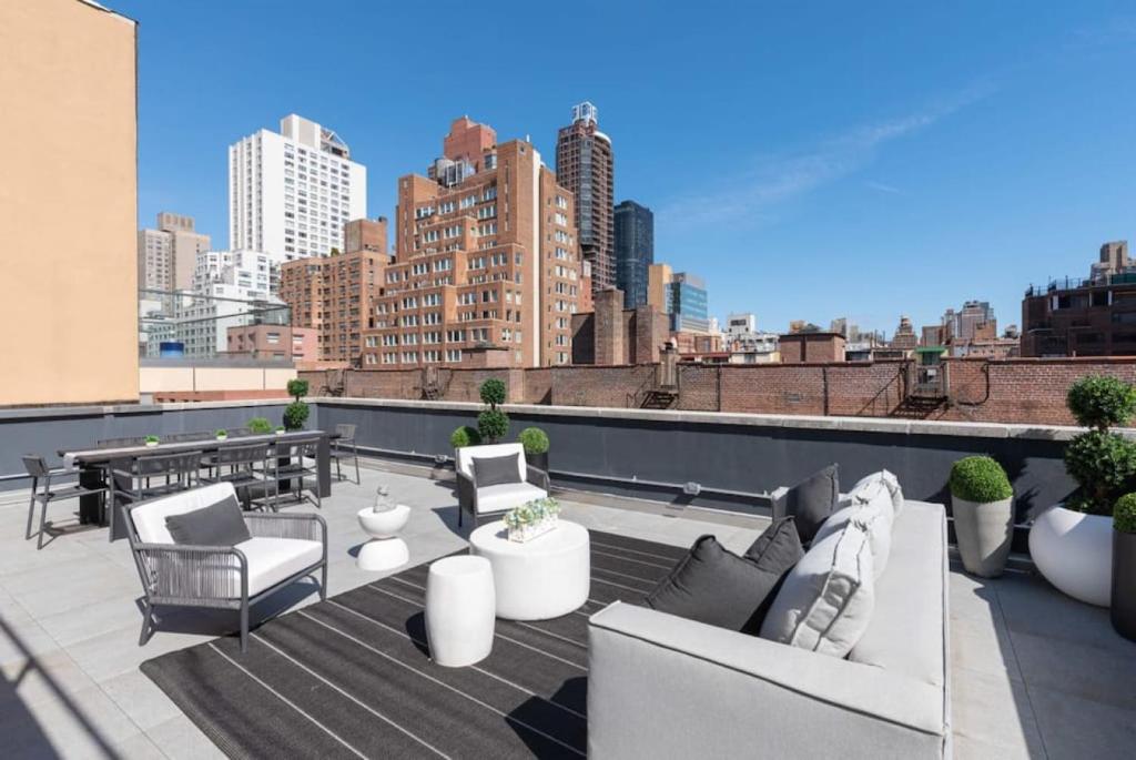 a rooftop patio with furniture and a view of a city at 3BR Penthouse with Massive Private Rooftop in New York