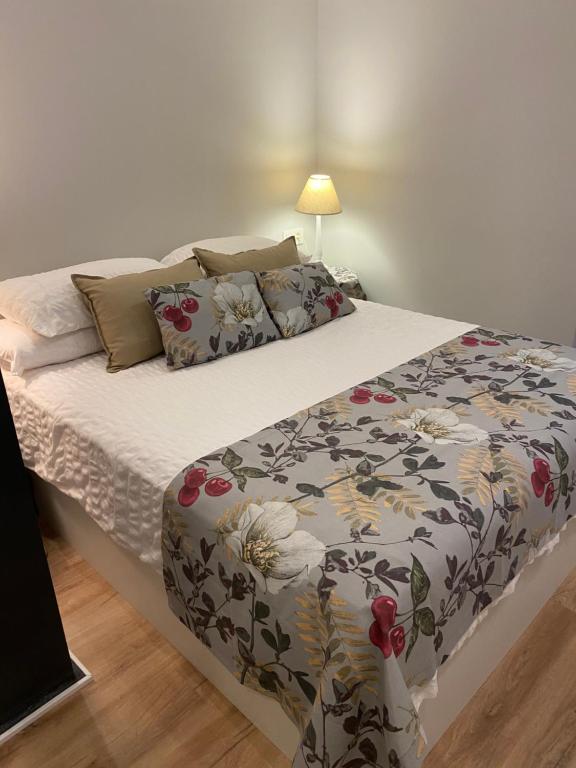a bedroom with a bed with a flower patterned blanket at Precioso y céntrico apartamento in Zaragoza