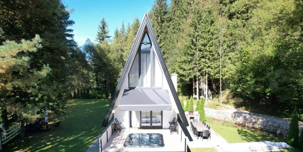 a small white chapel with a pool in the yard at Swiss House Sarajevo in Trnovo