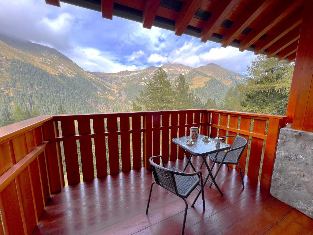 a table and chairs on a balcony with a view of mountains at Affittimoderni San Simone - Appartamento Sci Sole in Valleve