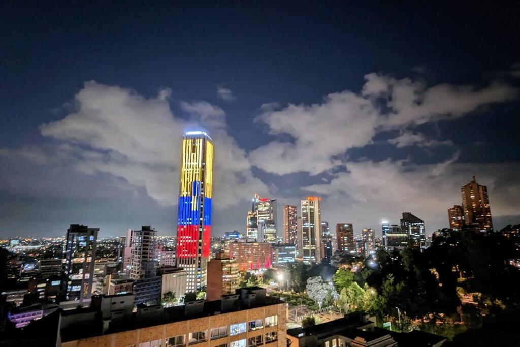 a city skyline at night with a lit up building at Acogedor Apartaestudio Amoblado Centro Internacional, Bogotá in Bogotá