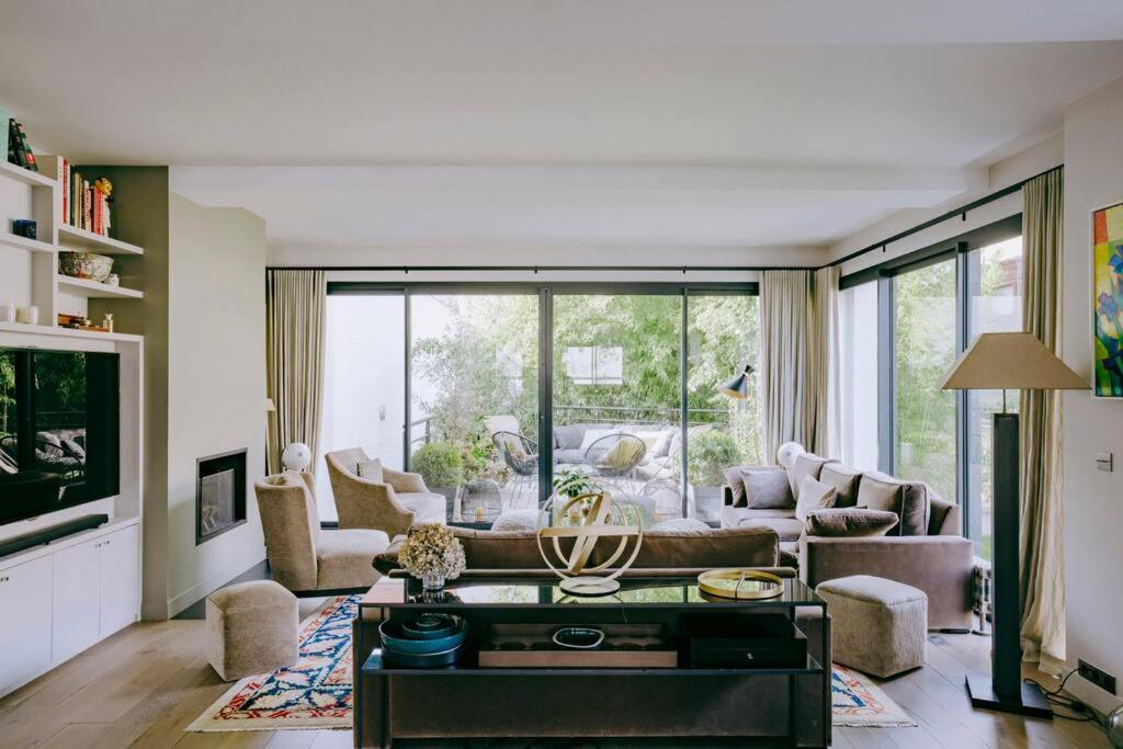 ein Wohnzimmer mit einem Sofa und einem Tisch in der Unterkunft Luxury house for 8 - 3 terraces - By Askmefrance in Boulogne-Billancourt