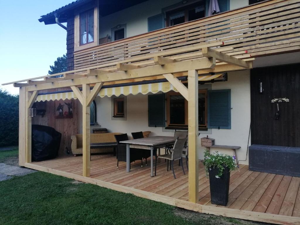 a wooden deck with a pergola on a house at Dopplerhof's Staufenhaus in Piding