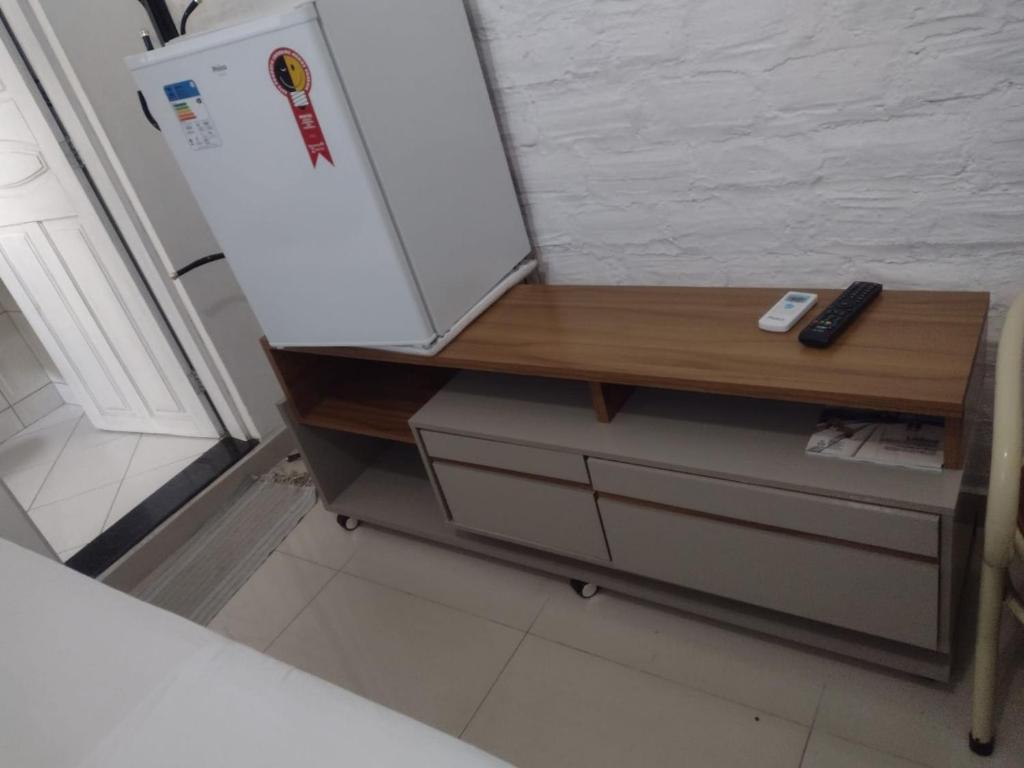 einen weißen Kühlschrank mit einer Holztheke in der Küche in der Unterkunft Pousada Palace Hotel in Caruaru