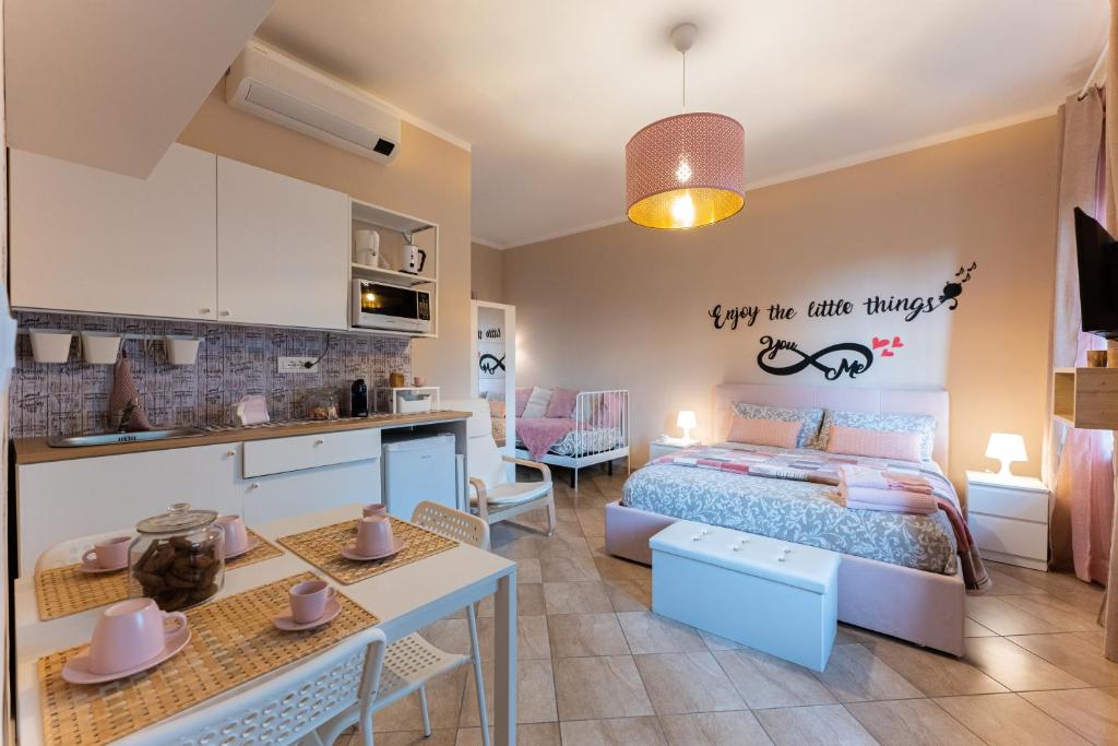 a bedroom with a bed and a kitchen in a room at Le fantasie di Tizi in Alpignano