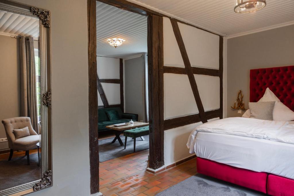 1 dormitorio con espejo grande y 1 habitación con cama en Gutshauszimmer Premium Doppel, en Neu Gaarz