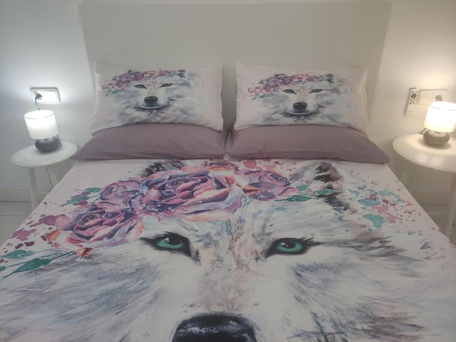 a bed with two wolf pillows with flowers on it at Team019 Sitges Richard España in Sant Pere de Ribes
