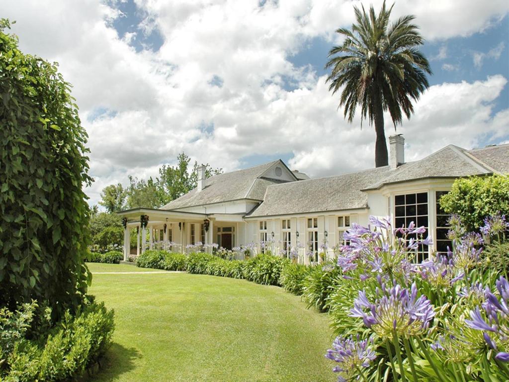 an exterior view of a house with a garden at Chateau Yering in Yarra Glen