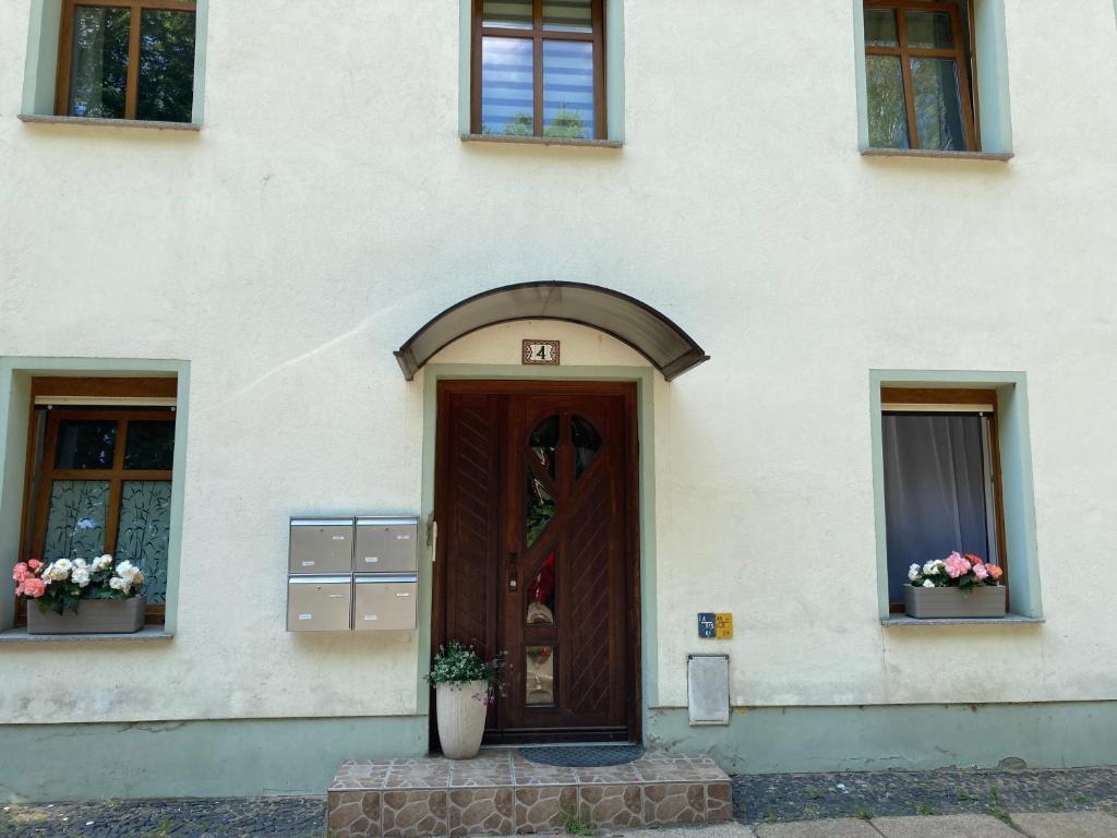 a door of a building with flowers in the windows at Gästezimmer in Görlitz