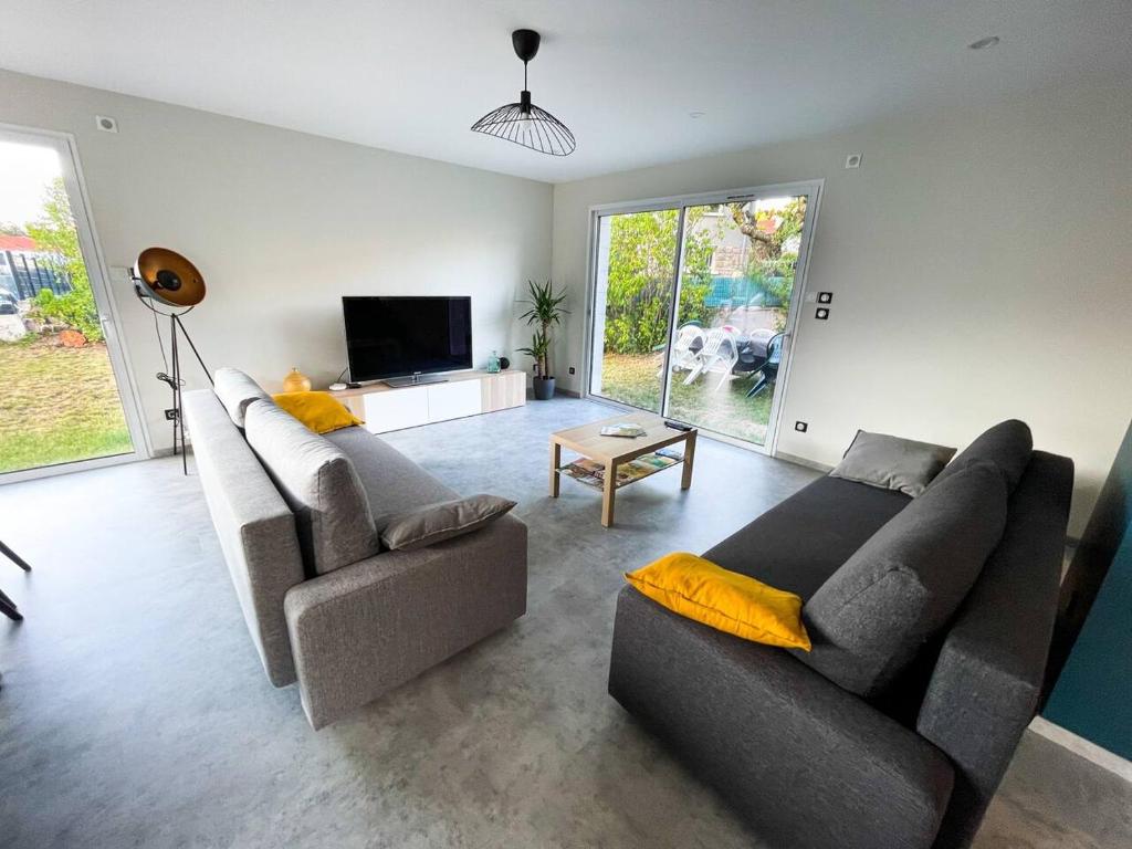 sala de estar con 2 sofás y TV en La Maison de Juliette, en Le Puy en Velay