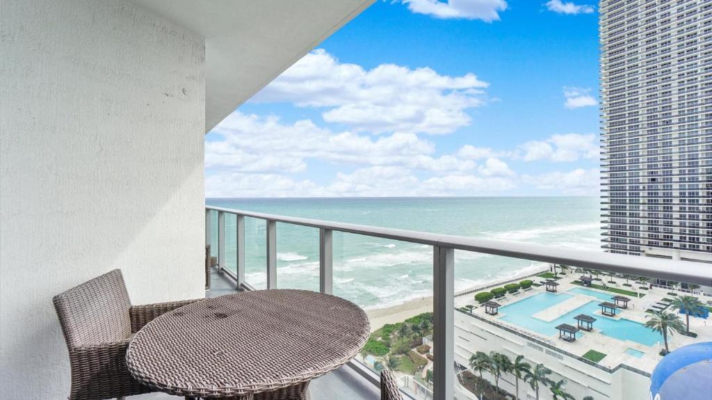 哈蘭代爾海灘的住宿－2 BR Beach condo ocean views at Hyde MIiami，阳台配有桌子,享有海景。