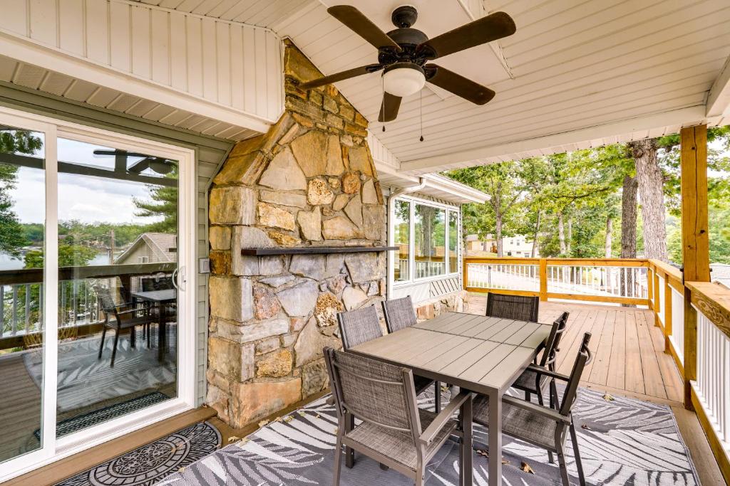 a porch with a table and a stone fireplace at Sunrise Beach Home on the Lake of the Ozarks! in Sunrise Beach