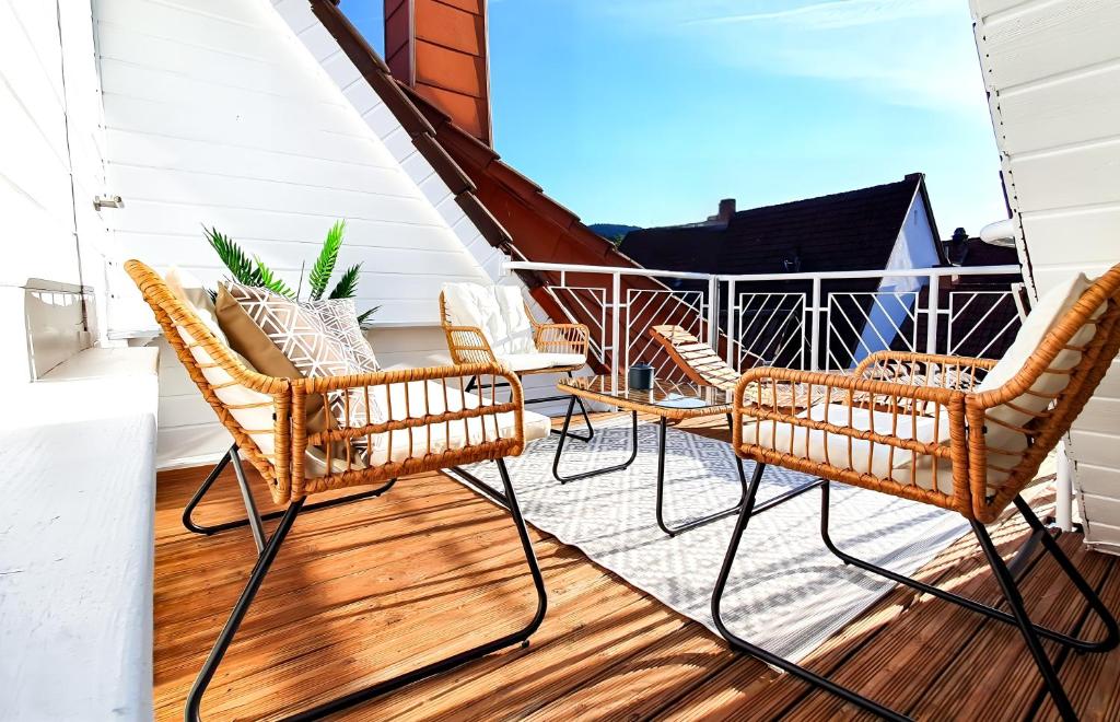d'une terrasse avec des chaises et une table sur un balcon. dans l'établissement ROMANTIC-Apartment, Dachterrasse, Waldblick, Maisonette, Free Coffee, 90m2, à Annweiler am Trifels