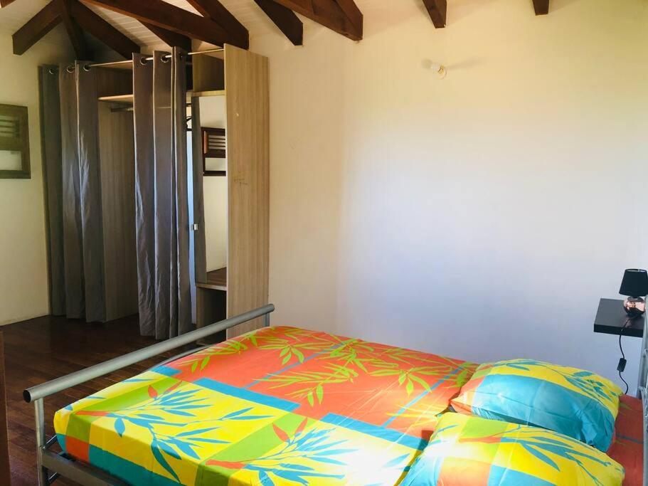 a bed with a colorful comforter in a room at Sainte Luce_Villa_Piscine avec vue mer_wifi in Sainte-Luce