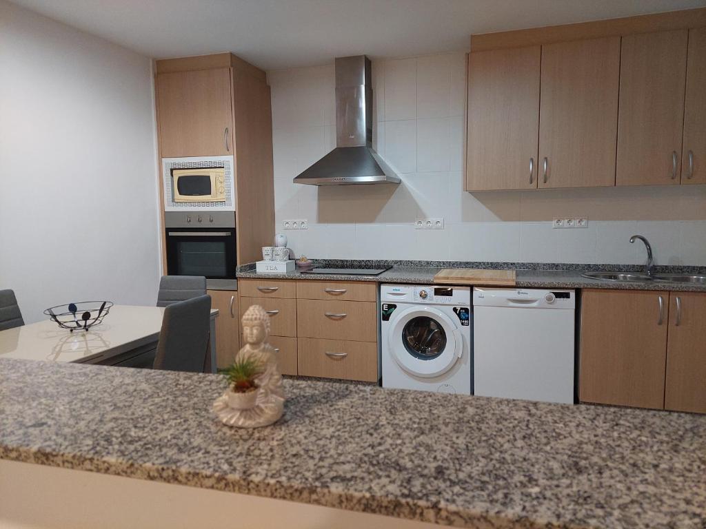 a kitchen with a counter top with a washing machine at Casita en la playa in Boiro