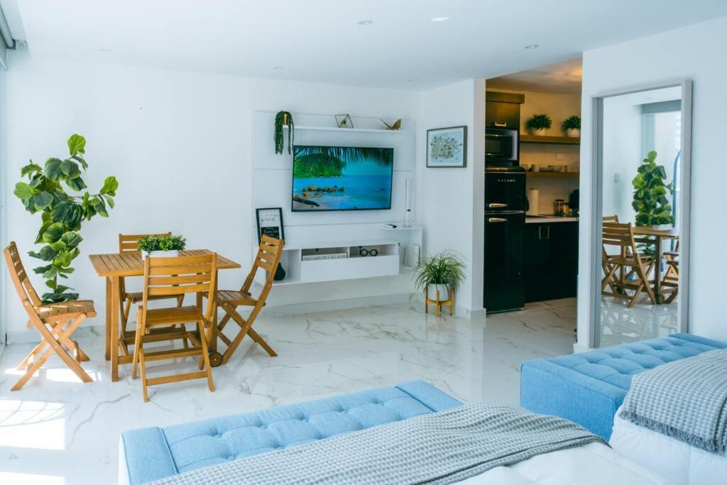 ein Wohnzimmer mit einem blauen Sofa und einem Tisch in der Unterkunft Buena Vida Beach Studio Puerto Rico in San Juan